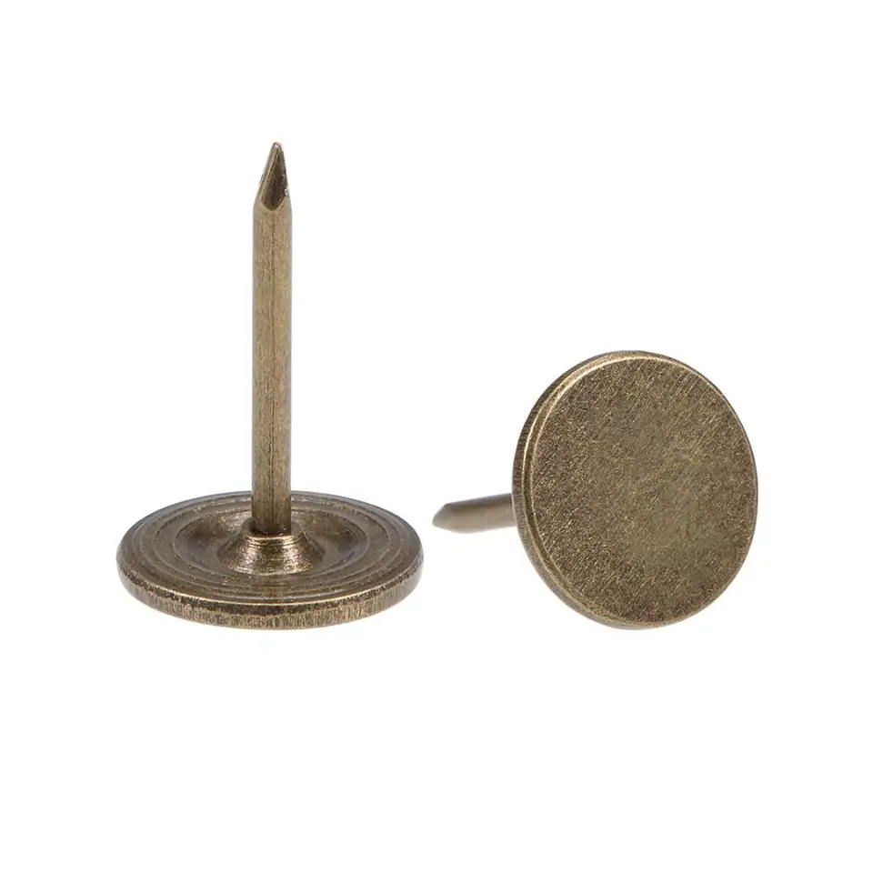 Upholstery Tacks Screwfix: Two brass tacks, one upright, one on its side, on white.