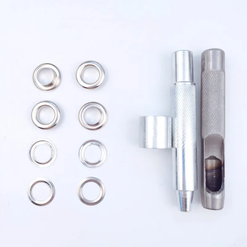 Eyelets for tarpaulin with installation tools on a plain white background.