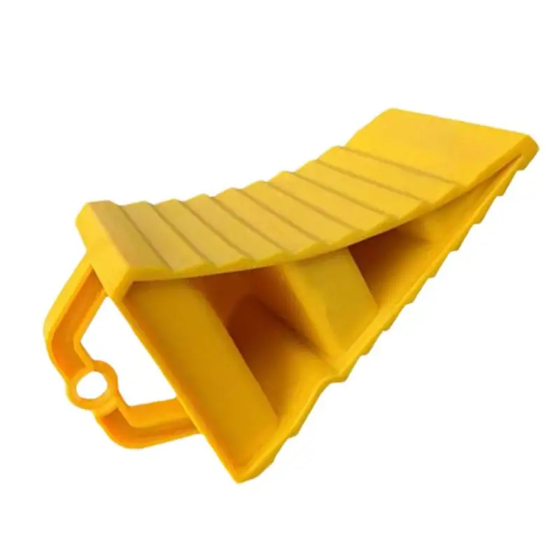 A black heavy-duty wheel chock with a yellow handle, designed for securing vehicles and preventing movement.