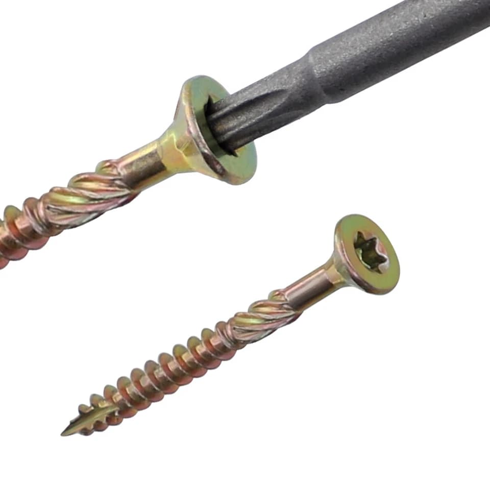 Galvanised Deck Screws T25 being driven by a screwdriver bit on a white background.