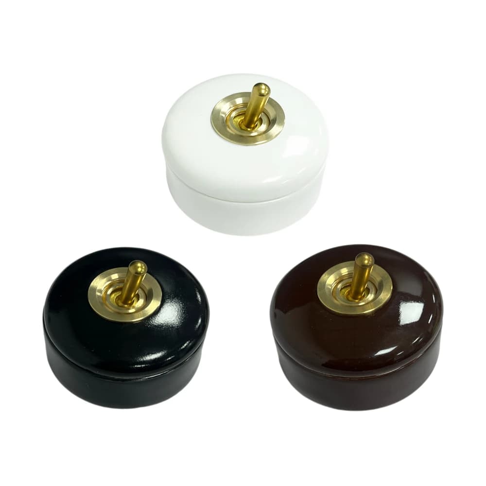 Retro ceramic wall light switch with a brass lever for one-way or two-way control, featuring a round toggle and vintage rocker design.