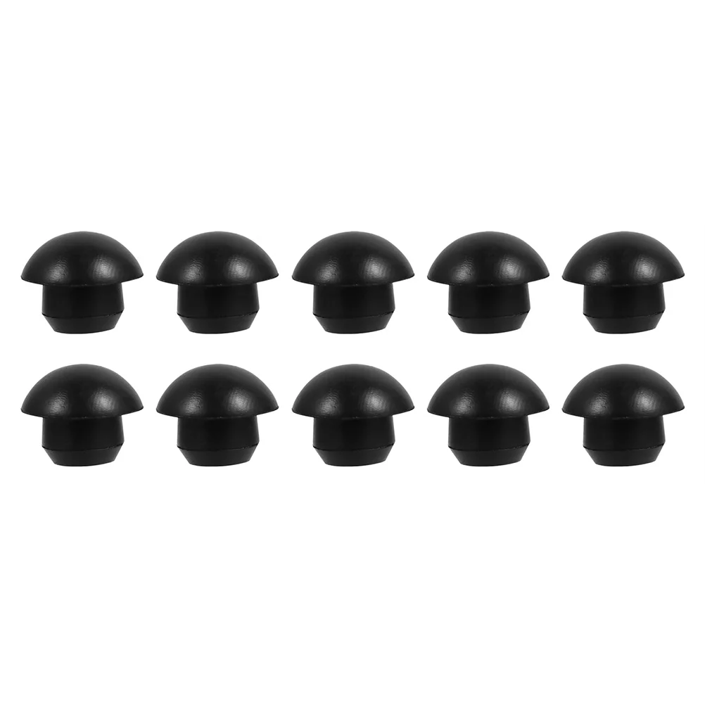 10-piece set of black rubber hydraulic bung plugs for sealing floor-level oil reservoir filler necks on industrial machinery.