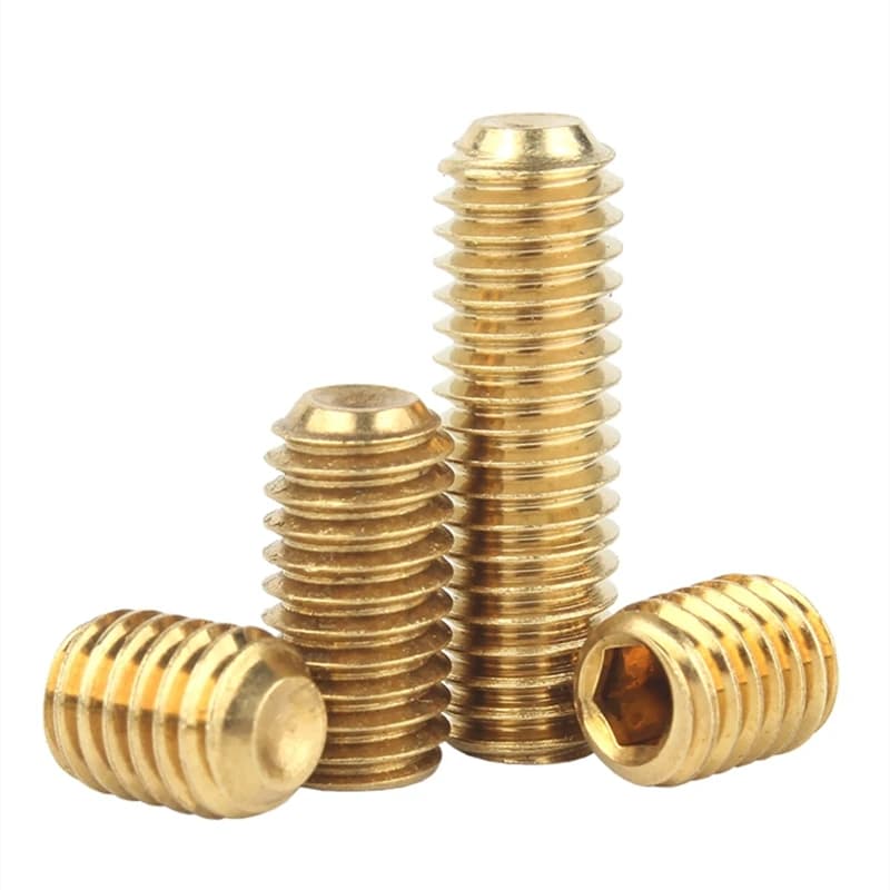 Four brass grub screws on a white background.
