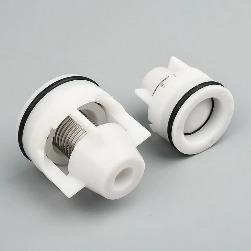 Double check valve components: white plastic, black O-rings, and a visible spring.