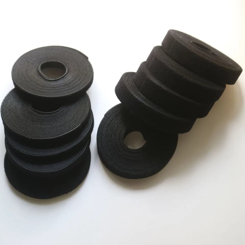 Hook and loop tape: multiple black rolls on a light background.