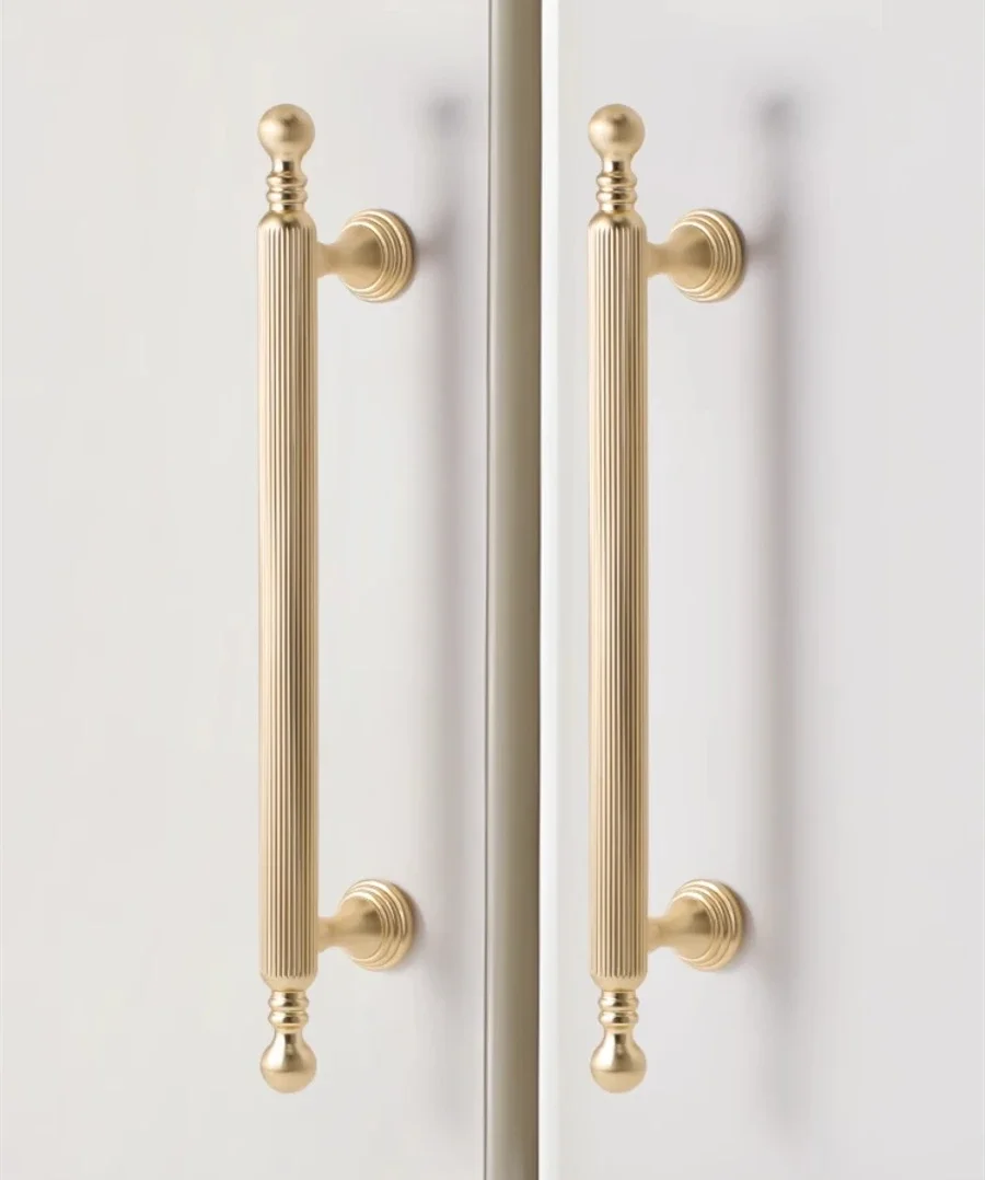 French-style cabinet door handles in light luxury gold and black with vertical grain, featuring both pulls and small knobs.