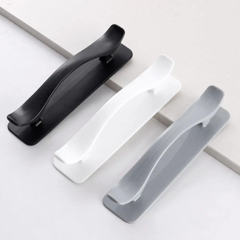 Self-adhesive plastic door handle requiring no drilling, designed for cabinets, wardrobes, and furniture with easy peel-and-stick installation.