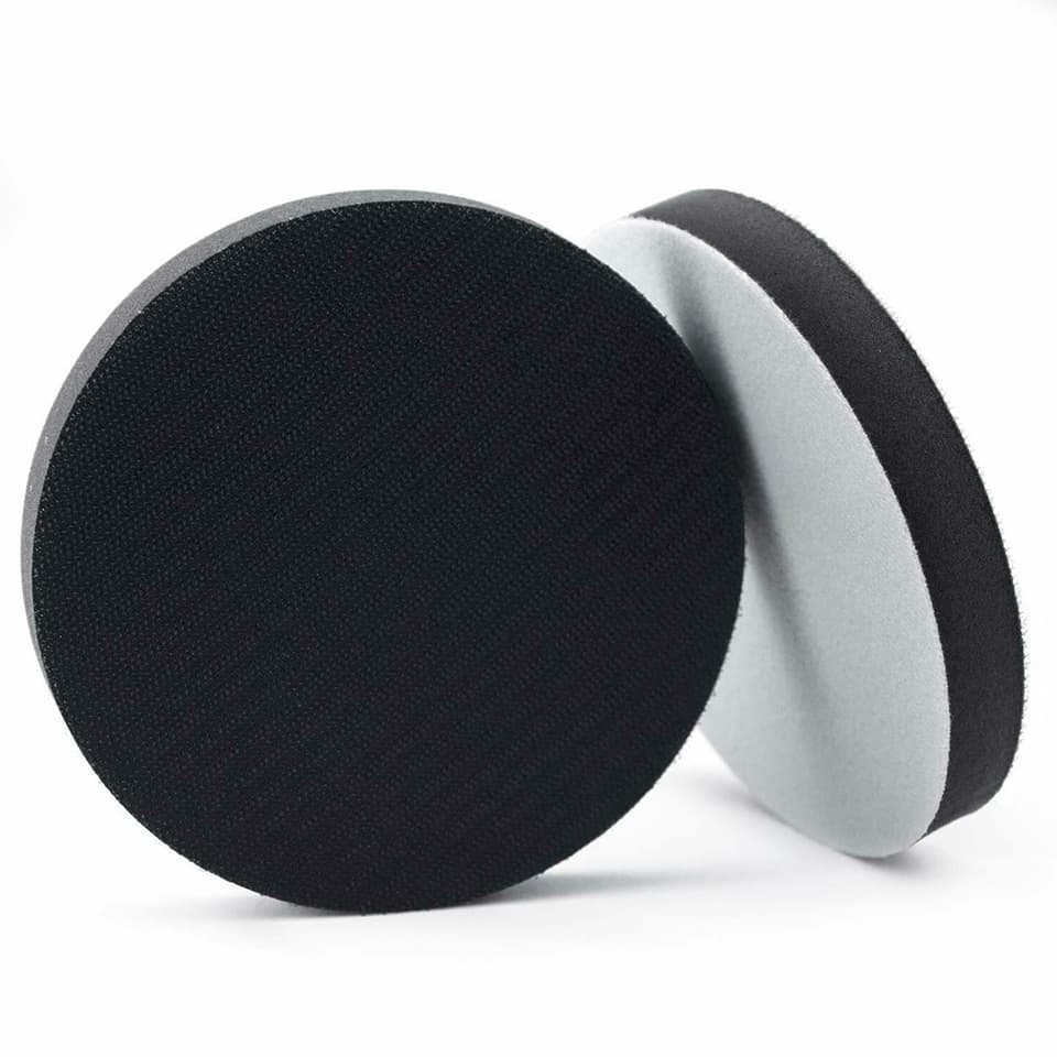 Soft sponge interface pads for an orbital sander pad, 5 inches in diameter, shown in a stack.