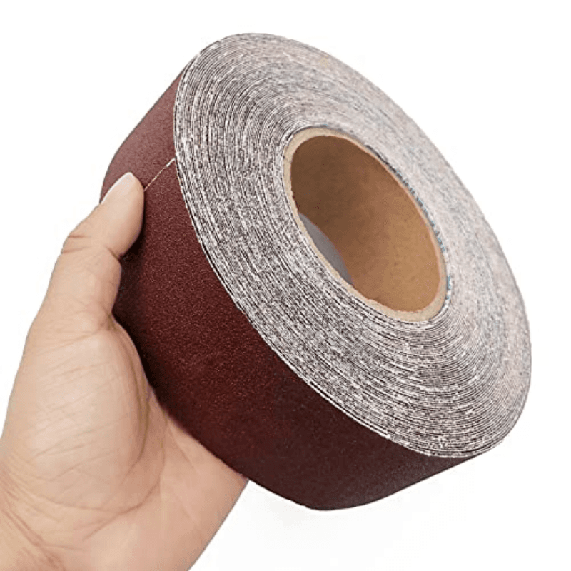 A continuous roll of abrasive emery cloth sandpaper, ready to cut for a bench sander or other applications.